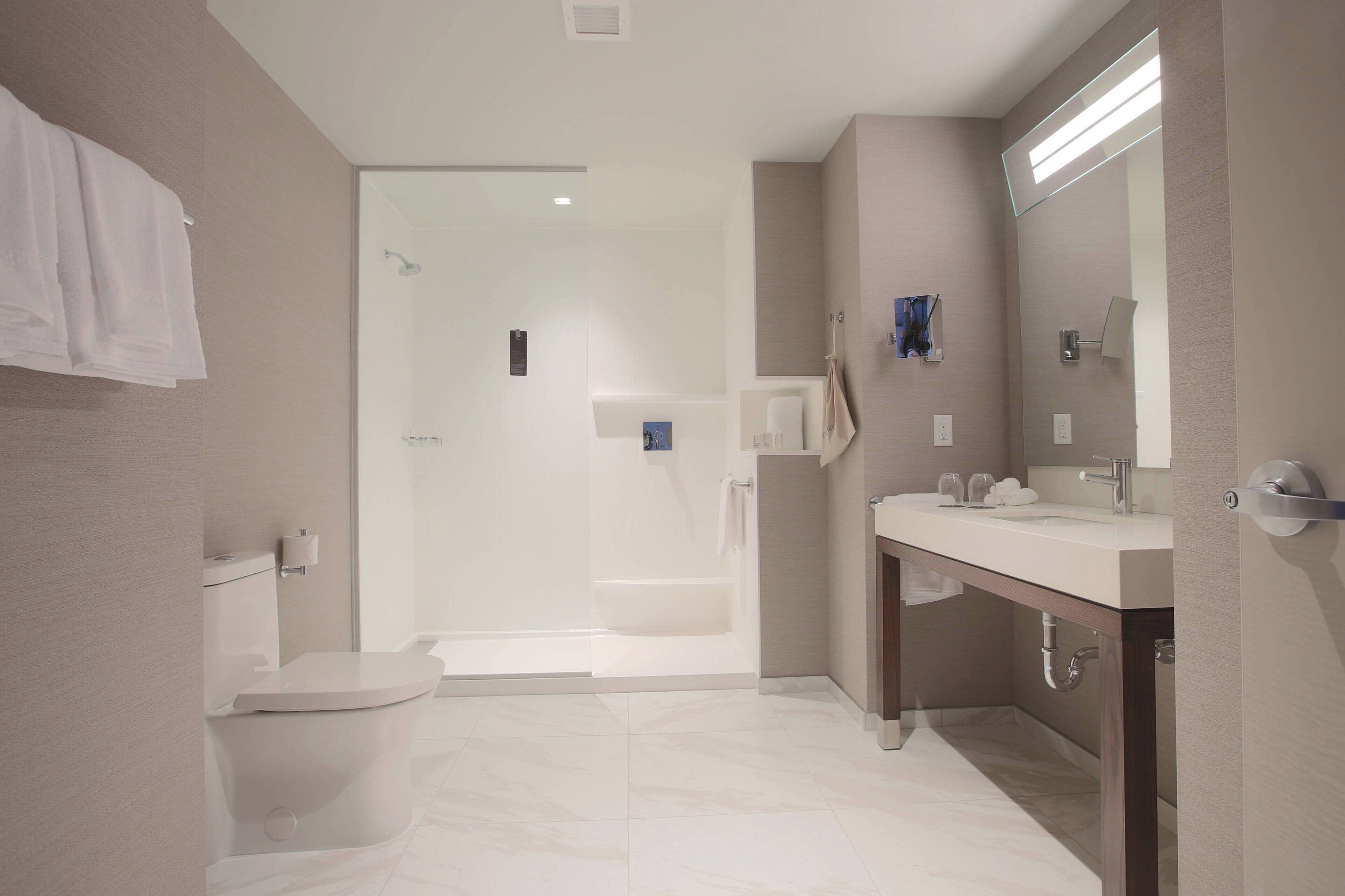 Un baño moderno con inodoro, ducha y lavamanos.