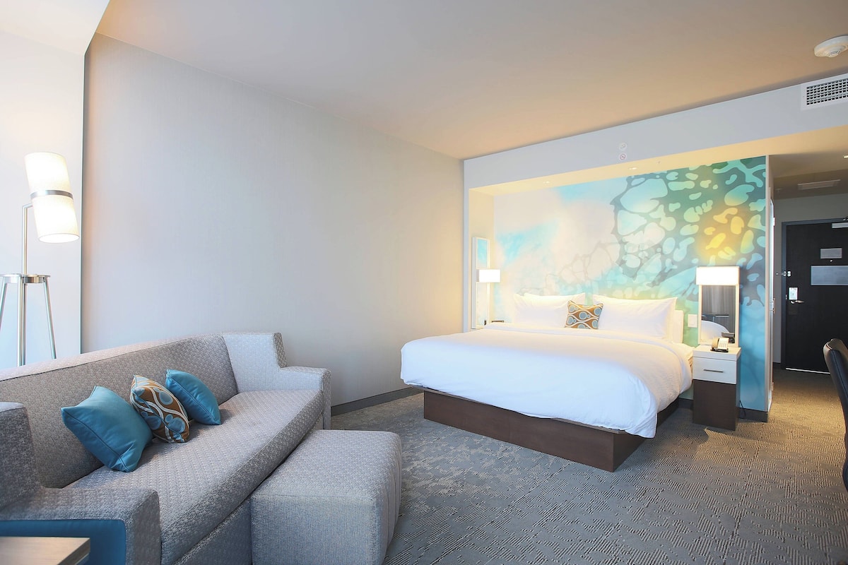 Ein Hotelzimmer mit einem Bett, einer Couch und einem Nachttisch.