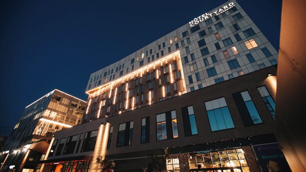 Un hôtel moderne avec une enseigne bien visible indiquant « HÔTEL YARD SYNERGY ».