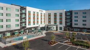 A modern hotel with a pool, outdoor seating, and a parking lot. - Element by Marriott San Jose Milpitas (Milpitas)