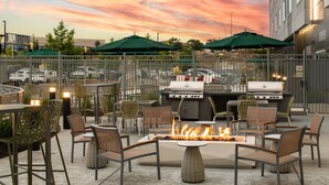 An outdoor patio with a fire pit, grilling stations, and outdoor seating. - Element by Marriott San Jose Milpitas (Milpitas)