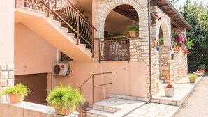 A building with a stone archway entrance, a staircase with metal railings, and potted plants. - Apartment 1706/17819 (Istria - Liznjan), 1250m from the beach (Liznjan)