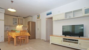 Ett kompakt bostadsutrymme med matplats, kök och vardagsrum.