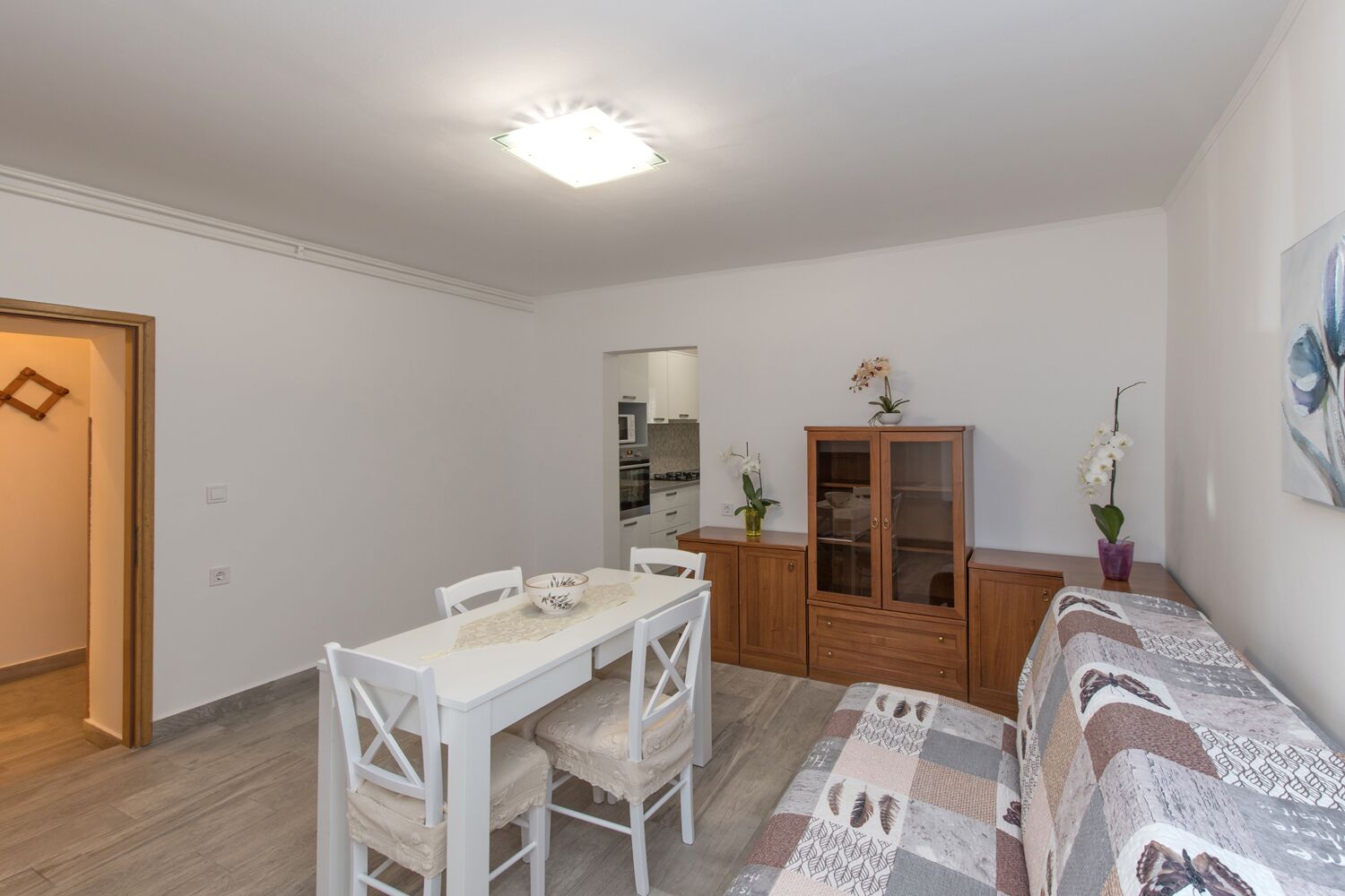 A compact living space with a dining area, a kitchenette, and a sofa.