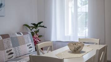 Un coin repas avec une table, des chaises et un bol posé sur un set de table.
