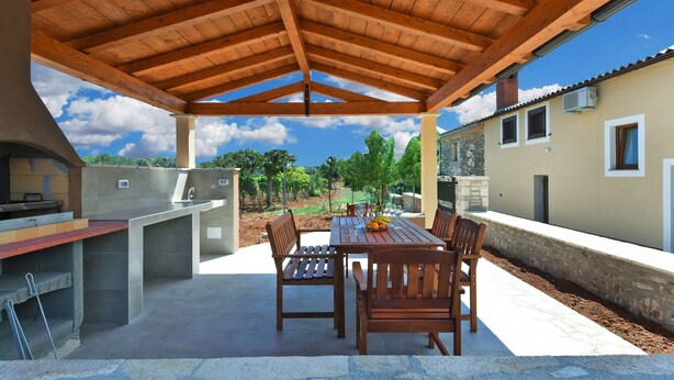 An outdoor patio with a wooden pergola, a barbecue grill, and a dining table with chairs. - House 1735/17984 (Istria - Galižana), 5000m from the beach (Galižana)