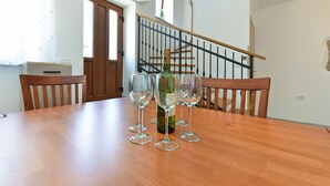 A dining table with a bottle of wine and several glasses. - House 1735/17984 (Istria - Galižana), 5000m from the beach (Galižana)