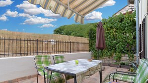 A patio with a table and chairs, a covered area, and a bamboo fence. - House 1736/17992 (Istria - Premantura), 600m from the beach (Premantura)