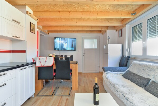 A compact living space with a kitchenette, a dining area, and a sofa.