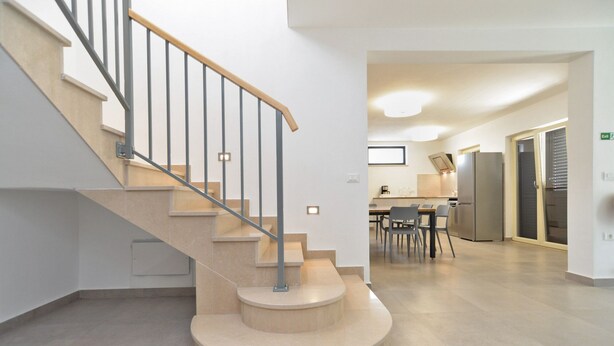 Un intérieur moderne avec un escalier à volutes, un espace cuisine et un coin repas.