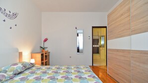 A bedroom with a bed, a nightstand, a mirror, and a wardrobe. - Apartment 1755/18834 (Istria - Svetvinčenat), 20000m from the beach (Svetvincenat)