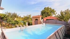 A rectangular swimming pool with a stone archway and a red-roofed building in the background. - Apartment 1755/18834 (Istria - Svetvinčenat), 20000m from the beach (Svetvincenat)