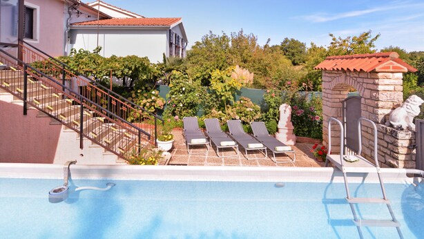 A swimming pool with lounge chairs, a stone structure, and a staircase leading to a building. - Apartment 1755/18834 (Istria - Svetvinčenat), 20000m from the beach (Svetvincenat)
