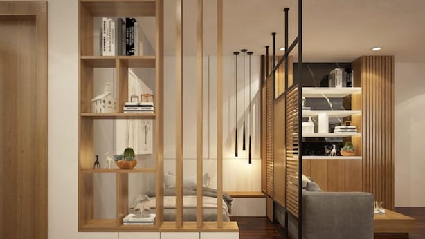 Una sala de estar moderna con una estantería de madera, un sofá gris y piso de madera.