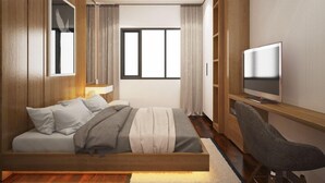 Un dormitorio moderno con cama, televisor y escritorio.