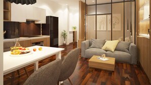 Una sala de estar moderna con un sofá gris, una mesa de centro de madera y un comedor con una mesa y sillas blancas.