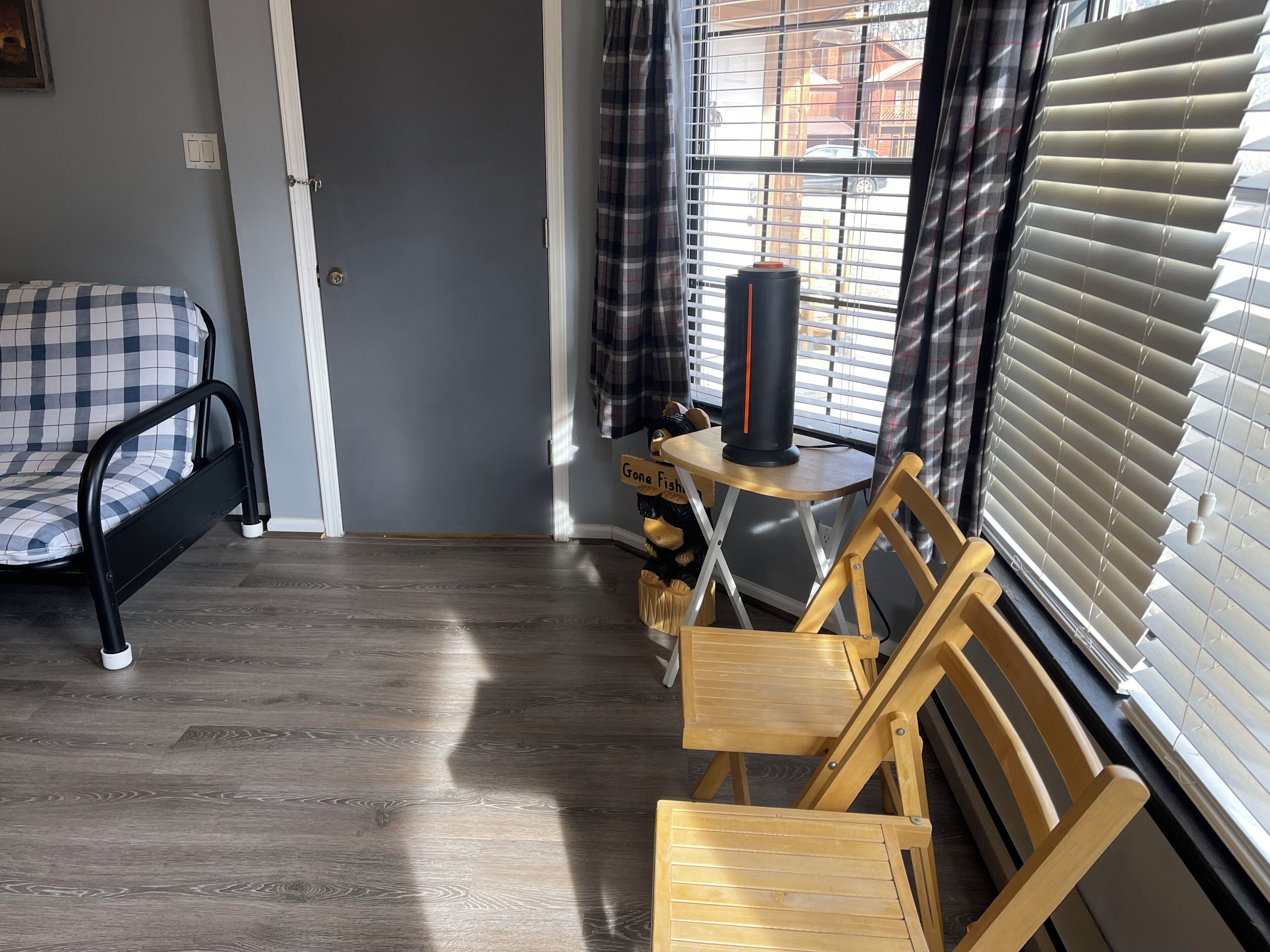 A room with a bed, a desk, a chair, and a window with blinds.
