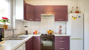 A modern kitchen with a gas stove, oven, and a white refrigerator. - House 1765/19674 (Istria - Peroj), 1000m from the beach (Peroj)
