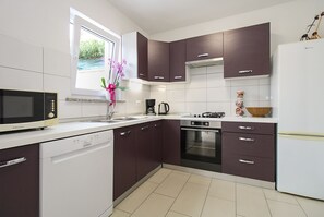 A modern kitchen with white and dark brown cabinets, a microwave, a dishwasher, a stove, and a refrigerator. - House 1765/19674 (Istria - Peroj), 1000m from the beach (Peroj)