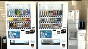 Two vending machines with a variety of beverages and snacks, and a water dispenser to the right.