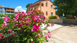 Un edificio con facciata in pietra, diverse finestre e un balcone.