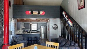 A modern interior with a dining area, kitchen, and a staircase. - Riverbend 8A Townhouse (Red River)