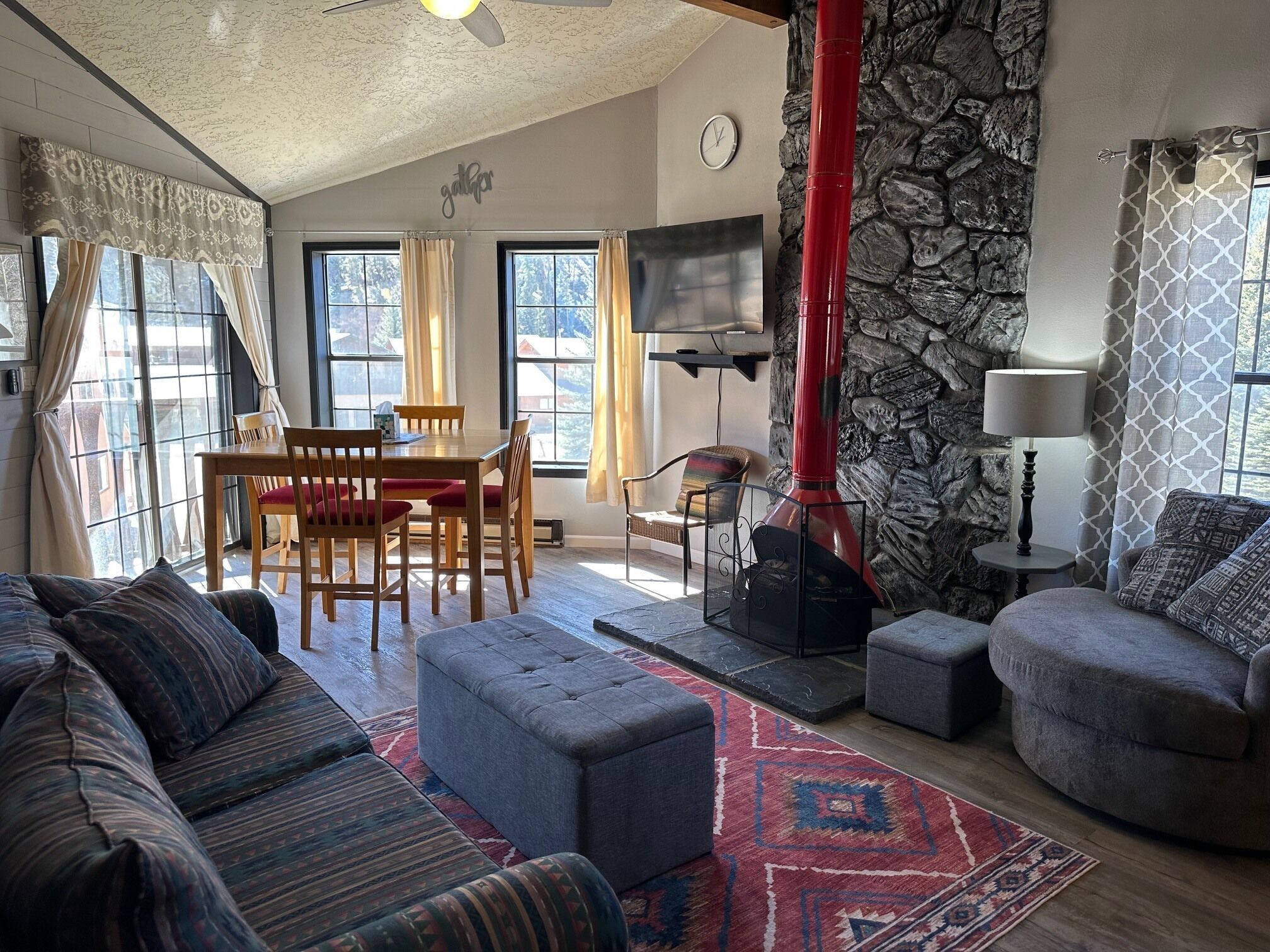 Ein gemütliches Wohnzimmer mit Kamin, Essbereich und Sofa.