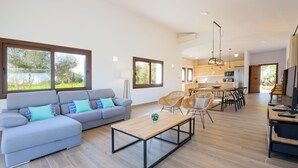 A modern living room with a sofa, coffee table, and dining area. - Bona Vista with private pool, A/C, table tennis, WiFi, quiet location (Felanitx)