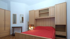 A bedroom with a bed, wooden wardrobe, and a desk. - Apartment 1775/20467 (Istria - Medulin), 750m from the beach (Medulin)