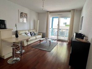 Uma sala de estar moderna com um sofá, mesa de centro e área de jantar.