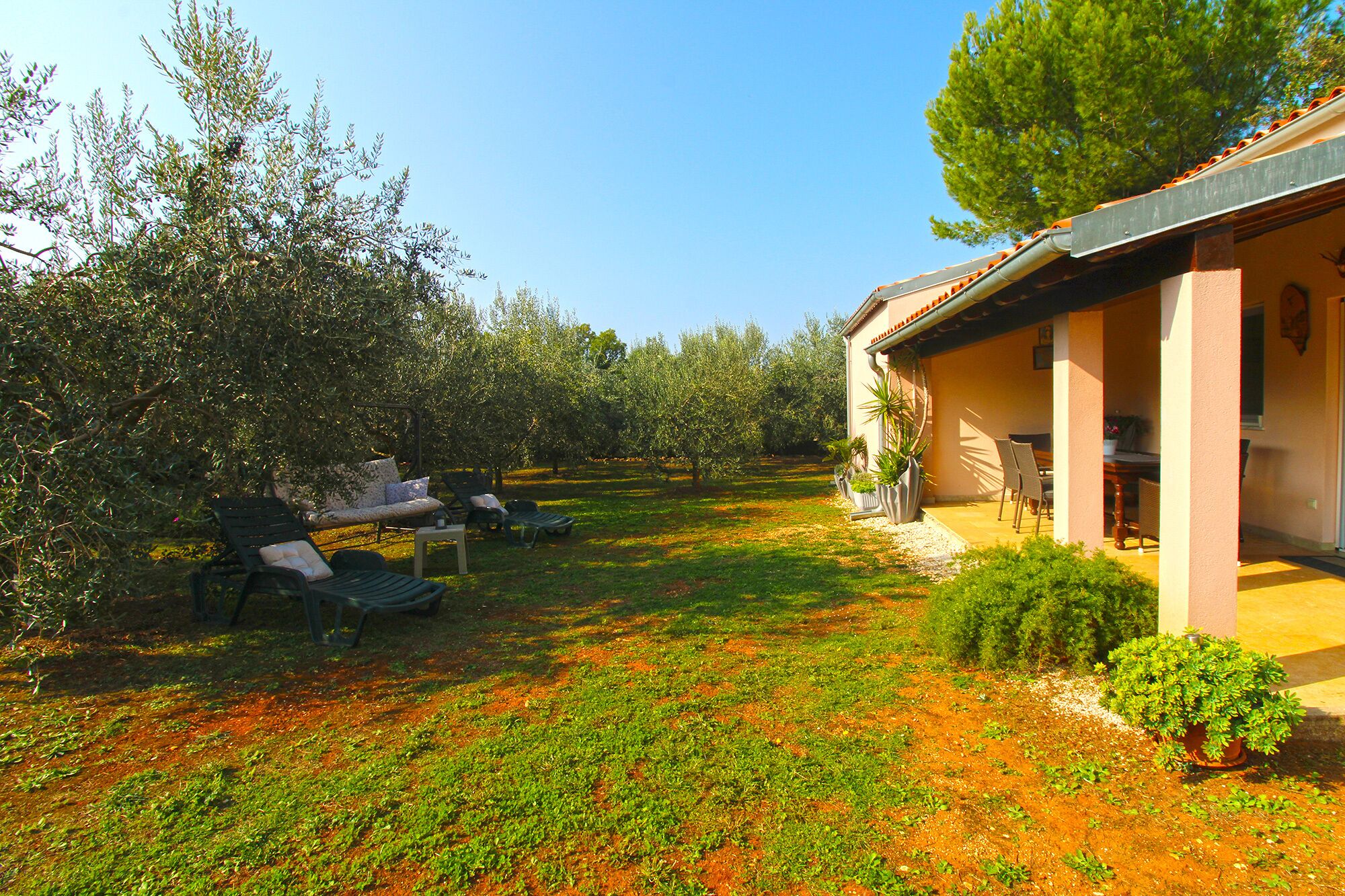 A garden with outdoor seating and a building with a covered patio.