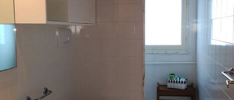 Ein Badezimmer mit Marmorwaschbecken, Toilette und Fenster.