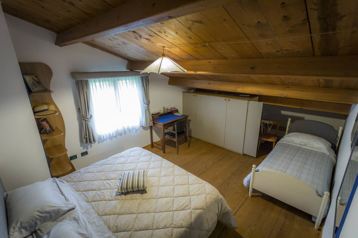 Une chambre à coucher avec un lit, un bureau et une armoire.