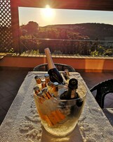 Una mesa con una botella de champán, hielo y copas, ubicada en un balcón con vistas panorámicas.