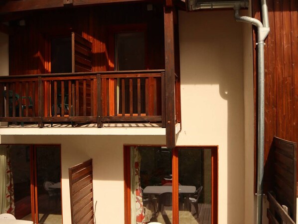 A two-story building with a balcony and large windows.