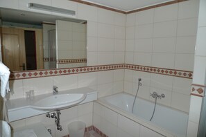 Un baño con lavabo, espejo y bañera.