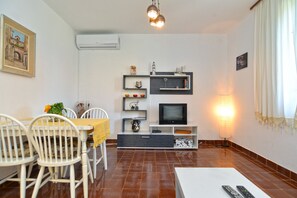 Cozy living space with a dining area, flat-screen TV, and comfortable seating.