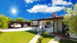 A residential property with a covered patio, a garage with two cars, and a well-maintained lawn. - House 1818/21520 (Istria - Pula), 5000m from the beach (Pula)