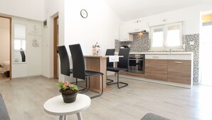 A modern kitchen with two black chairs, a dining table, and a small potted plant. - House 1818/21520 (Istria - Pula), 5000m from the beach (Pula)