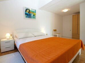 A bedroom with a bed, a nightstand, a chair, a wardrobe, and a painting on the wall. - House 1823/21658 (Istria - Vinkuran), 750m from the beach (Vinkuran)
