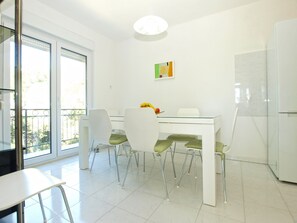 A modern kitchen with white cabinets, a glass dining table, and four chairs. - House 1823/21658 (Istria - Vinkuran), 750m from the beach (Vinkuran)