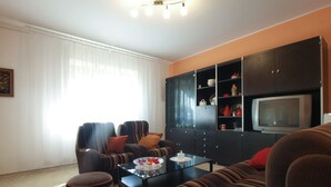 A living room with striped sofas, a coffee table, and a television on a cabinet. - Apartment 1827/21673 (Istria - Pula), 4500m from the beach (Pula)