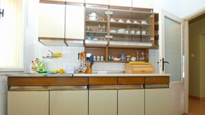 A kitchen with wooden cabinets, a sink, and various kitchen utensils. - Apartment 1827/21673 (Istria - Pula), 4500m from the beach (Pula)