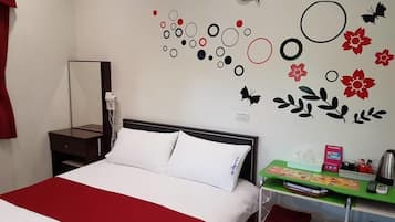 A hotel room with a bed, a desk, and a wall decorated with circular and floral decals.