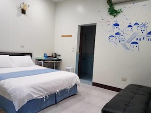 Un dormitorio con cama, escritorio y decoración en la pared.