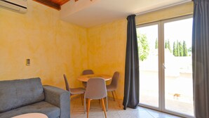 A room with a sofa, a dining table with chairs, a sliding glass door, and a ceiling fan. - Apartment 1838/21894 (Istria - Pomer), 400m from the beach (Pomer)
