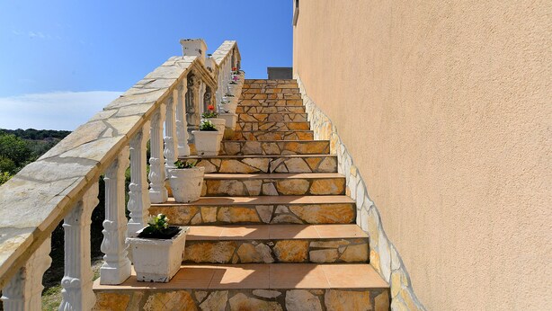 A stone staircase with white railings and potted plants, leading up a building with a beige exterior. - Apartment 1838/21894 (Istria - Pomer), 400m from the beach (Pomer)