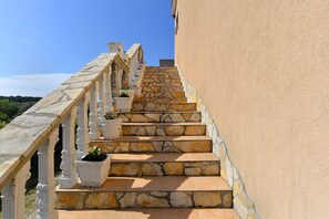 A stone staircase with white railings and potted plants, leading up to a building with a beige exterior. - Apartment 1838/21894 (Istria - Pomer), 400m from the beach (Pomer)