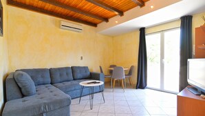 A living room with a sectional sofa, a small round table, and a television. - Apartment 1838/21894 (Istria - Pomer), 400m from the beach (Pomer)
