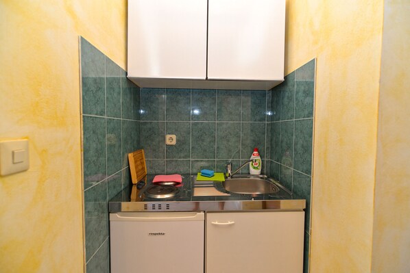 A compact kitchen with a dishwasher, a sink, and a small countertop.